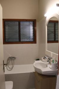 a bathroom with a sink and a toilet and a mirror at Villa Khaki in Fíkhtion +61 photos