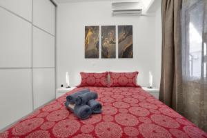 a bedroom with a red bed with two teddy bears on it at Athenian Destiny Suite in Athens