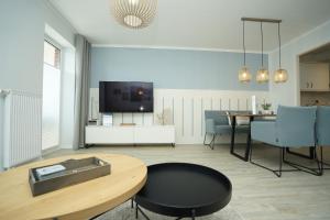 a living room with a table and a tv at Seeblick - a57219 in Cuxhaven