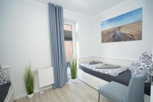 a white room with a bed and a window at Seeblick - a57219 in Cuxhaven