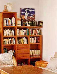 uma estante cheia de livros numa sala de estar em Casa Rural Cal Baté em Pratdip