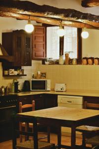 cocina con mesa de madera y cocina con encimera en Casa Rural Cal Baté en Pratdip