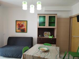 a living room with a table and a chair and a couch at Bilo Olivieri Porto Cesareo in Porto Cesareo