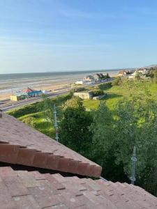 - une vue sur la plage depuis le toit d'une maison dans l'établissement Studio cosy vue mer et campagne, à Villers-sur-Mer