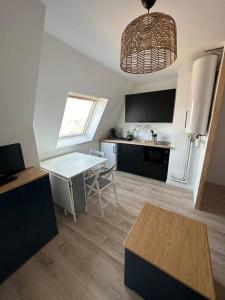 Il comprend une cuisine équipée d'une table et d'un réfrigérateur blanc. dans l'établissement Studio cosy vue mer et campagne, à Villers-sur-Mer