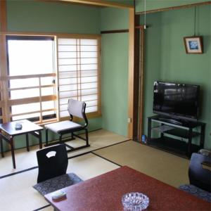 a living room with a television and a table and chairs at Nisshokan in Ise +5 photos