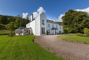 a large white house with a gravel driveway at Killean Farmhouse B&B in Inveraray