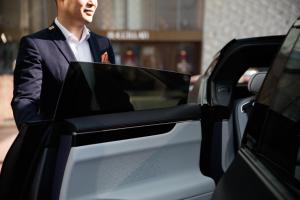 a man in a suit getting into a car at The Ritz-Carlton Shanghai, Pudong in Shanghai