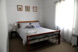 a bedroom with a bed with a black and white comforter at Curnows in Bendigo