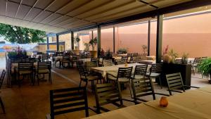 a restaurant with tables and chairs and windows at Hotel Due Fratelli in Senftenberg