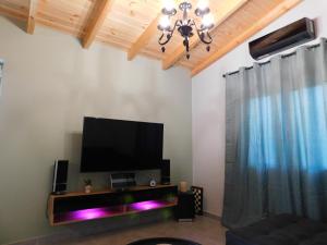 a living room with a flat screen tv on a wall at M & M House in Ayiá