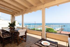 a porch with a table and chairs and a view of the ocean at Penelope Home in Panormos Rethymno