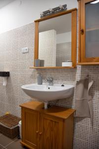 a bathroom with a sink and a mirror at Csillagvirág Apartman Gyula in Gyula