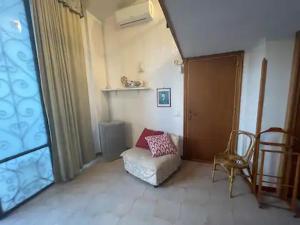 a living room with a chair and a window at la Dacia di Gina in Ravello