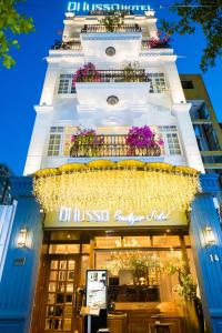 a store front of a building with lights and flowers at Di Lusso Boutique Riverside Danang Hotel in Da Nang