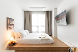 a bedroom with a large white bed with a window at Urbanstay Boutique Ikseon in Seoul