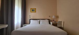 1 dormitorio con cama blanca y ventana en Villa Riari Garden, en Roma