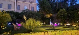 einen Garten mit Stühlen und ein Gebäude in der Nacht in der Unterkunft Villa Riari Garden in Rom