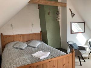 1 dormitorio con 1 cama grande y 1 silla en Jungshoved Præstegård B&B, en Præstø