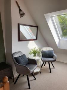 - un salon avec deux chaises et un miroir dans l'établissement Jungshoved Præstegård B&B, à Præstø