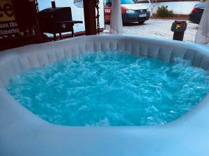 a hot tub filled with blue water in a backyard at Guest House Eden in Bihać