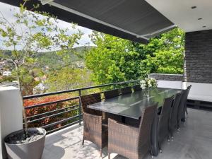 ein Esszimmer mit einem Tisch und Stühlen auf dem Balkon in der Unterkunft Private Family Villa in Budaörs