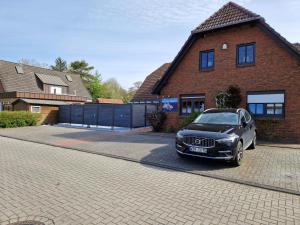 un coche aparcado frente a una casa de ladrillo en Haus Schilling, en Esens