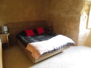 - un lit avec 2 oreillers rouges dans l'établissement La Bastide de la Reine Margot, à Beaumont