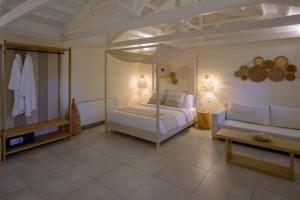 a bedroom with a canopy bed and a couch at Oikies Small Elegant Houses in Mytilini +55 photos