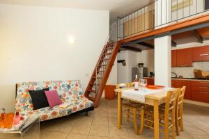 a living room with a dining room table and a staircase at La casa di NONNO ELIGIO in Bari Sardo