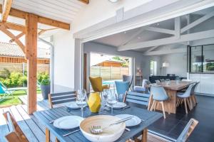 - une salle à manger avec une table et des chaises dans l'établissement La villa Sirelis piscine et spa, à Gujan-Mestras