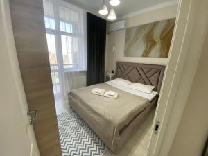 una camera da letto con un letto e due asciugamani di Alau Apartments a Astana