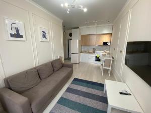 un soggiorno con divano e una cucina di Alau Apartments a Astana