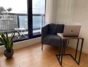 uma sala de estar com uma cadeira e um computador portátil sobre uma mesa em Scandinavian Brand New 2 Bedroom Apartment em Istambul