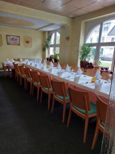 a long table with white tables and chairs in a room at Hotel Due Fratelli in Senftenberg