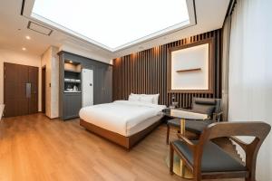 1 dormitorio con cama, escritorio y silla en Hotel Demer Mokpo en Mokpo