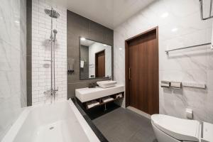 a bathroom with a tub and a sink and a toilet at Hotel Demer Mokpo in Mokpo