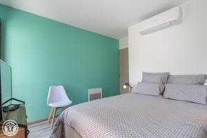 a bedroom with a bed and a blue wall at Gite Annecy 103- Au royaume des Castors - Appt 103 in Doussard