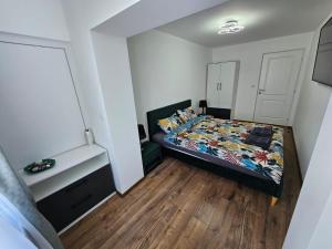- une petite chambre avec un lit et du parquet dans l'établissement Modern Residence Scala, à Zalău