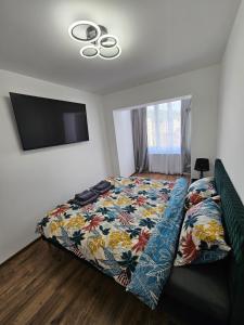 a bedroom with a bed with a colorful quilt on it at Modern Residence Scala in Zalău