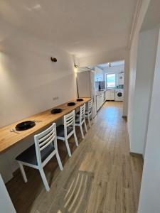 a kitchen with a long table and some chairs at Modern Residence Scala in Zalău