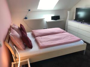 a bedroom with a bed with pink sheets and a tv at ARLALPIN in Pettneu am Arlberg