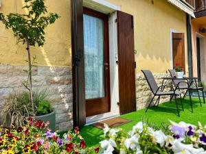 a front door of a house with a table and chairs at Al BORGO costermano sul garda via pertica 8A in Costermano sul Garda