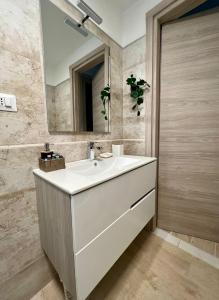 uma casa de banho com um lavatório branco e um espelho. em Al BORGO costermano sul garda via pertica 8A em Verona