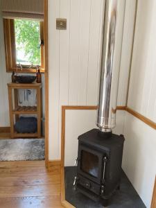 a stove in the corner of a room at The Hereford Hut, Charming 1 bedroom Shepherds Hut in Callow