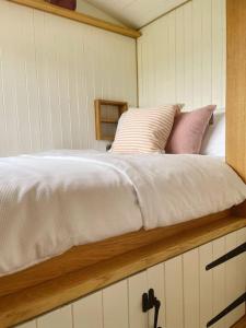 łóżko z poduszkami na górze kabiny w obiekcie The Hereford Hut, Charming 1 bedroom Shepherds Hut w mieście Callow