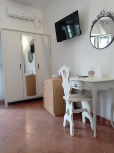 een kamer met een tafel, een stoel en een spiegel bij B&B Le Rose in Santa Maria di Castellabate