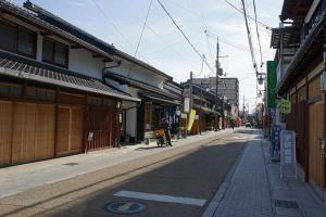 an empty city street with a person riding a bike at Hotel 21 in Kusatsu