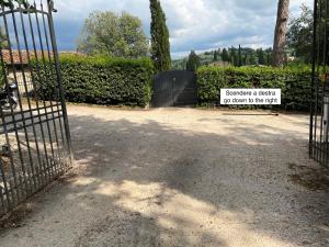 a gate with a sign that says volunteer a visitor do down to the left at Villetta Gabriella in Impruneta