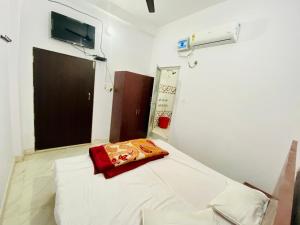 um quarto de hospital com uma cama com uma almofada vermelha em Rita Shree Homestay At Ayodhya Highway em Sultānpur